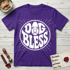 Dog Bless Greyhound T-Shirt flat lay in Purple, featuring Retro bubble-letter badge reading DOG BLESS with a slender Greyhound face with folded rose ears framed in the letter O, hand-drawn sunburst rays radiating outward.