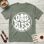 Dog Bless Greyhound T-Shirt flat lay in Sage, featuring Retro bubble-letter badge reading DOG BLESS with a slender Greyhound face with folded rose ears framed in the letter O, hand-drawn sunburst rays radiating outward.