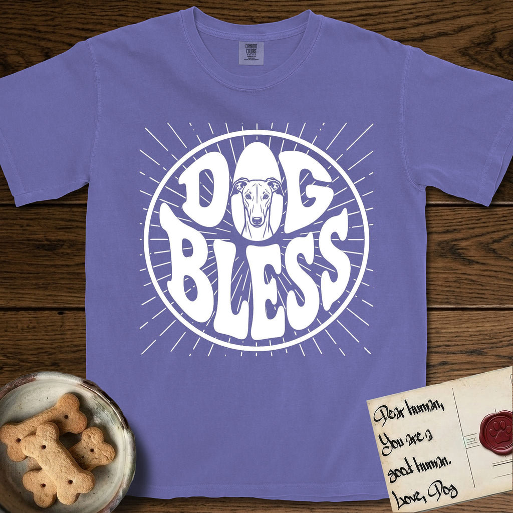 Dog Bless Greyhound T-Shirt flat lay in Violet, featuring Retro bubble-letter badge reading DOG BLESS with a slender Greyhound face with folded rose ears framed in the letter O, hand-drawn sunburst rays radiating outward.