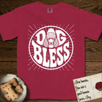 Dog Bless Poodle T-Shirt flat lay in Chili, featuring Retro bubble-letter badge reading DOG BLESS with a Poodle face with curly topknot and long curled ears framed in the letter O, hand-drawn sunburst rays radiating outward.
