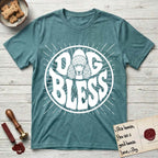Dog Bless Poodle T-Shirt flat lay in Heather Galapagos Blue, featuring Retro bubble-letter badge reading DOG BLESS with a Poodle face with curly topknot and long curled ears framed in the letter O, hand-drawn sunburst rays radiating outward.
