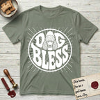 Dog Bless Poodle T-Shirt flat lay in Sage, featuring Retro bubble-letter badge reading DOG BLESS with a Poodle face with curly topknot and long curled ears framed in the letter O, hand-drawn sunburst rays radiating outward.