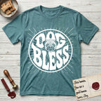 Dog Bless Pug T-Shirt flat lay in Heather Galapagos Blue, featuring Retro bubble-letter badge reading DOG BLESS with a wrinkled Pug face with large round eyes framed in the letter O, hand-drawn sunburst rays radiating outward.