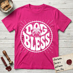 Dog Bless Pug T-Shirt flat lay in Heliconia, featuring Retro bubble-letter badge reading DOG BLESS with a wrinkled Pug face with large round eyes framed in the letter O, hand-drawn sunburst rays radiating outward.