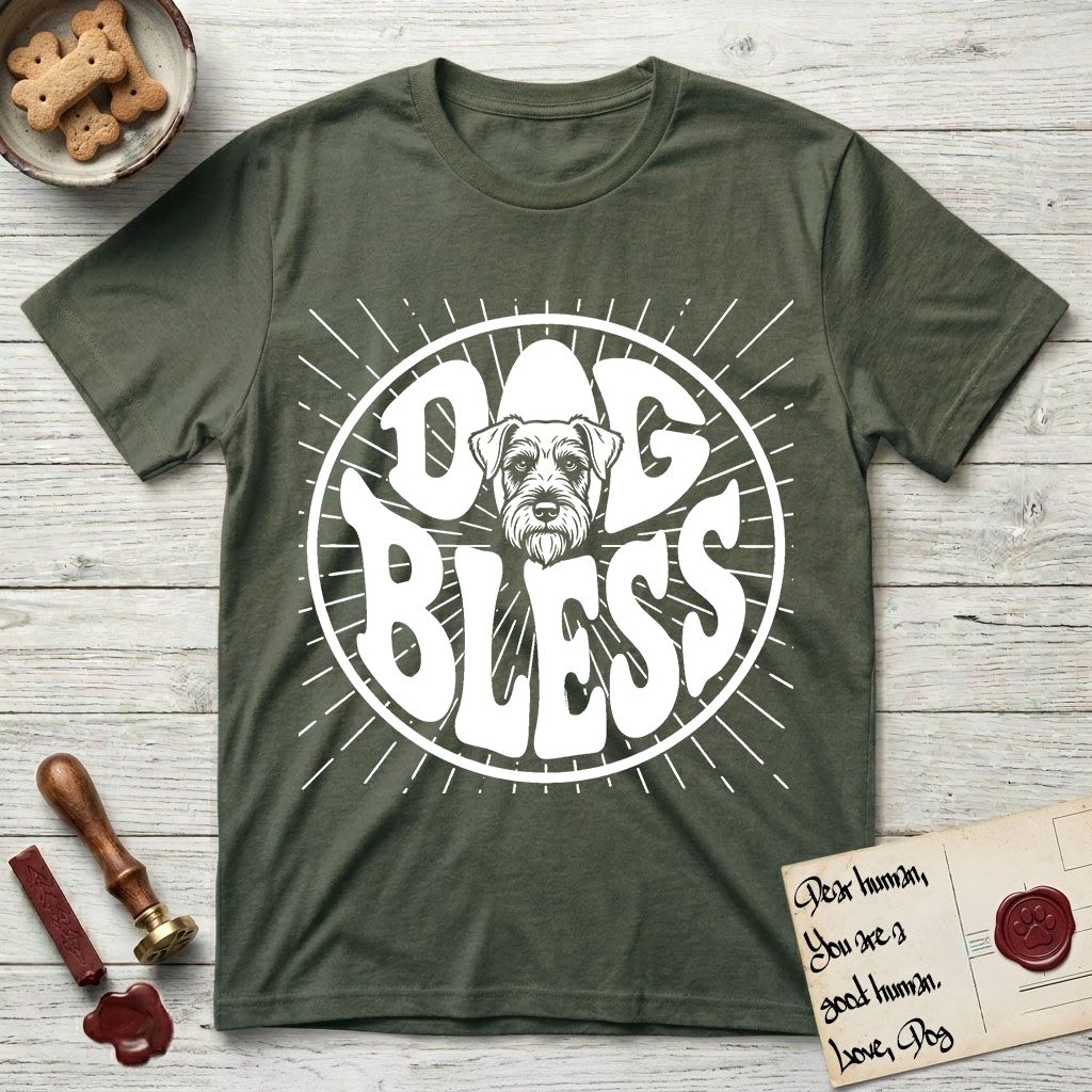 Dog Bless Schnauzer T-Shirt flat lay in Heather Military Green, featuring Retro bubble-letter badge reading DOG BLESS with a bearded Schnauzer face with bushy eyebrows framed in the letter O, hand-drawn sunburst rays radiating outward.