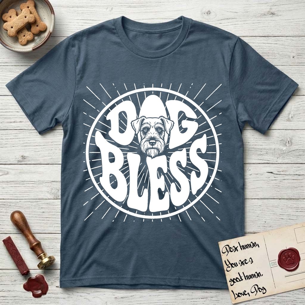 Dog Bless Schnauzer T-Shirt flat lay in Indigo Blue, featuring Retro bubble-letter badge reading DOG BLESS with a bearded Schnauzer face with bushy eyebrows framed in the letter O, hand-drawn sunburst rays radiating outward.