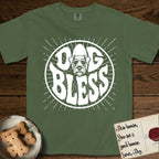 Dog Bless Schnauzer T-Shirt flat lay in Moss, featuring Retro bubble-letter badge reading DOG BLESS with a bearded Schnauzer face with bushy eyebrows framed in the letter O, hand-drawn sunburst rays radiating outward.