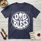 Dog Bless Schnauzer T-Shirt flat lay in Navy, featuring Retro bubble-letter badge reading DOG BLESS with a bearded Schnauzer face with bushy eyebrows framed in the letter O, hand-drawn sunburst rays radiating outward.