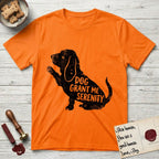 Serenity Basset Hound T-Shirt flat lay in Orange, featuring Distressed black screen print silhouette of a Basset Hound sitting in profile with one paw raised and long ears hanging, the words DOG GRANT ME SERENITY showing through his body in the shirt color.