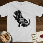 Serenity Basset Hound T-Shirt flat lay in White, featuring Distressed black screen print silhouette of a Basset Hound sitting in profile with one paw raised and long ears hanging, the words DOG GRANT ME SERENITY showing through his body in the shirt color.