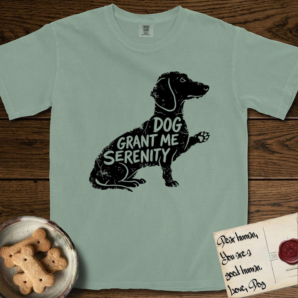 Serenity Dachshund T-Shirt flat lay in Bay, featuring Distressed black screen print silhouette of a Dachshund sitting in profile with one paw raised, a long low body and long hanging ears, the words DOG GRANT ME SERENITY showing through her body in the shirt color.