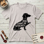 Serenity Dachshund T-Shirt flat lay in Ice Grey, featuring Distressed black screen print silhouette of a Dachshund sitting in profile with one paw raised, a long low body and long hanging ears, the words DOG GRANT ME SERENITY showing through her body in the shirt color.