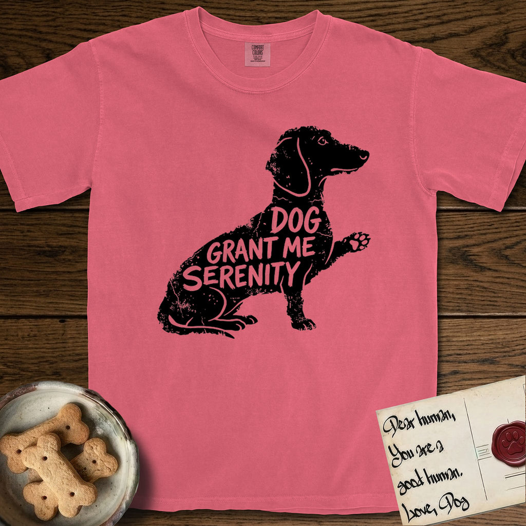 Serenity Dachshund T-Shirt flat lay in Watermelon, featuring Distressed black screen print silhouette of a Dachshund sitting in profile with one paw raised, a long low body and long hanging ears, the words DOG GRANT ME SERENITY showing through her body in the shirt color.