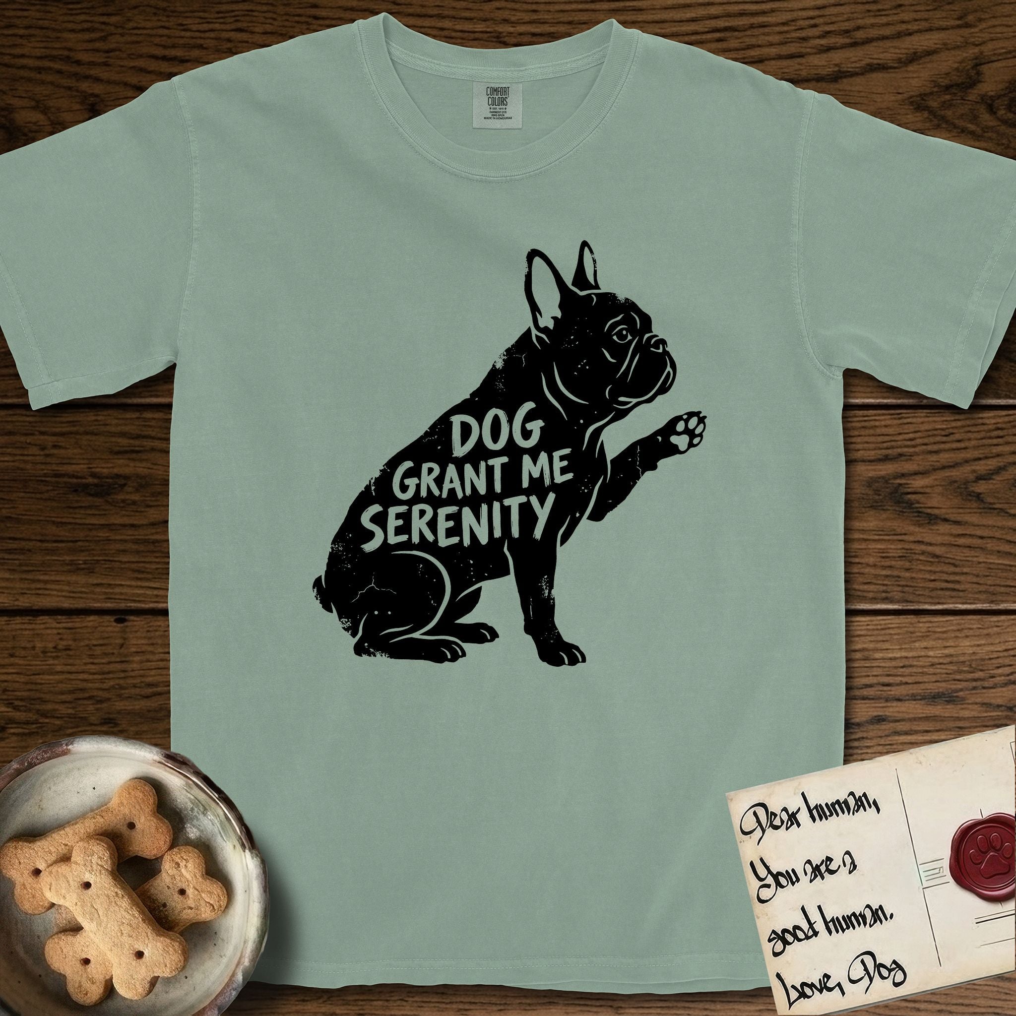 Serenity French Bulldog T-Shirt flat lay in Bay, featuring Distressed black screen print silhouette of a French Bulldog sitting in profile with one paw raised and large upright bat ears, the words DOG GRANT ME SERENITY showing through his body in the shirt color.