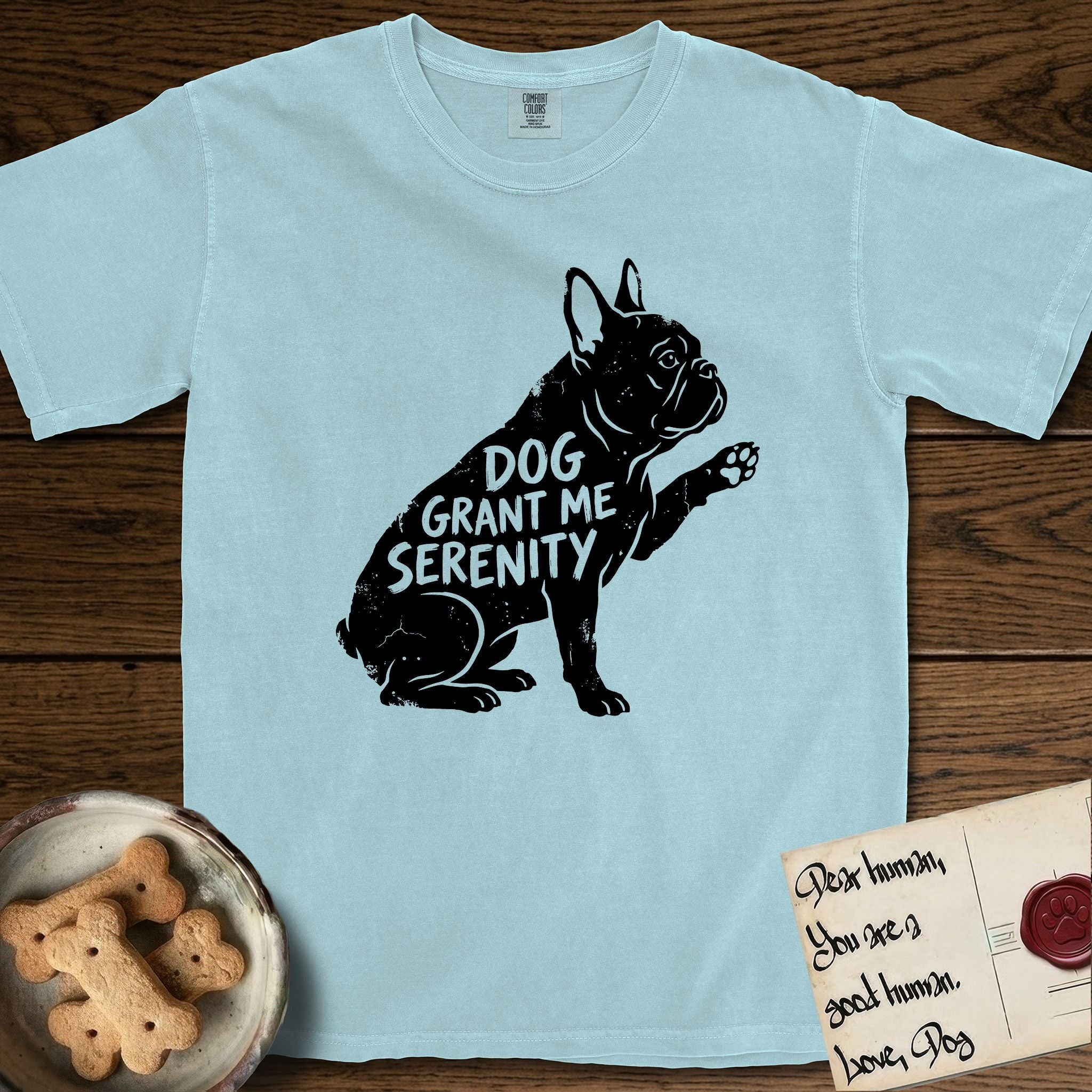 Serenity French Bulldog T-Shirt flat lay in Chambray, featuring Distressed black screen print silhouette of a French Bulldog sitting in profile with one paw raised and large upright bat ears, the words DOG GRANT ME SERENITY showing through his body in the shirt color.