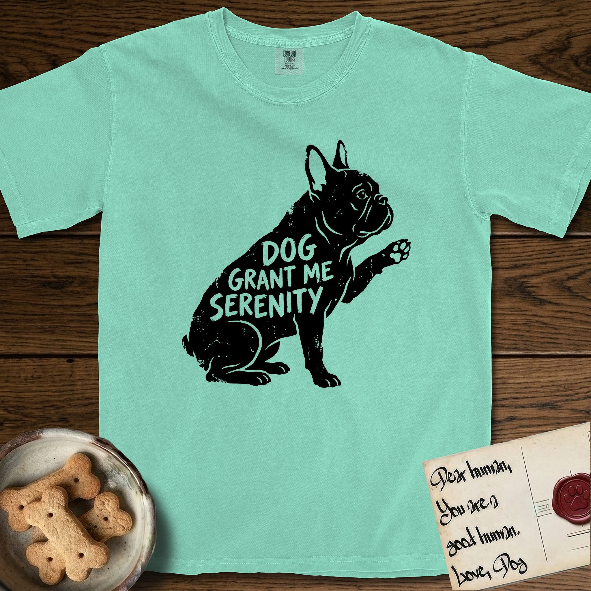 Serenity French Bulldog T-Shirt flat lay in Island Reef, featuring Distressed black screen print silhouette of a French Bulldog sitting in profile with one paw raised and large upright bat ears, the words DOG GRANT ME SERENITY showing through his body in the shirt color.