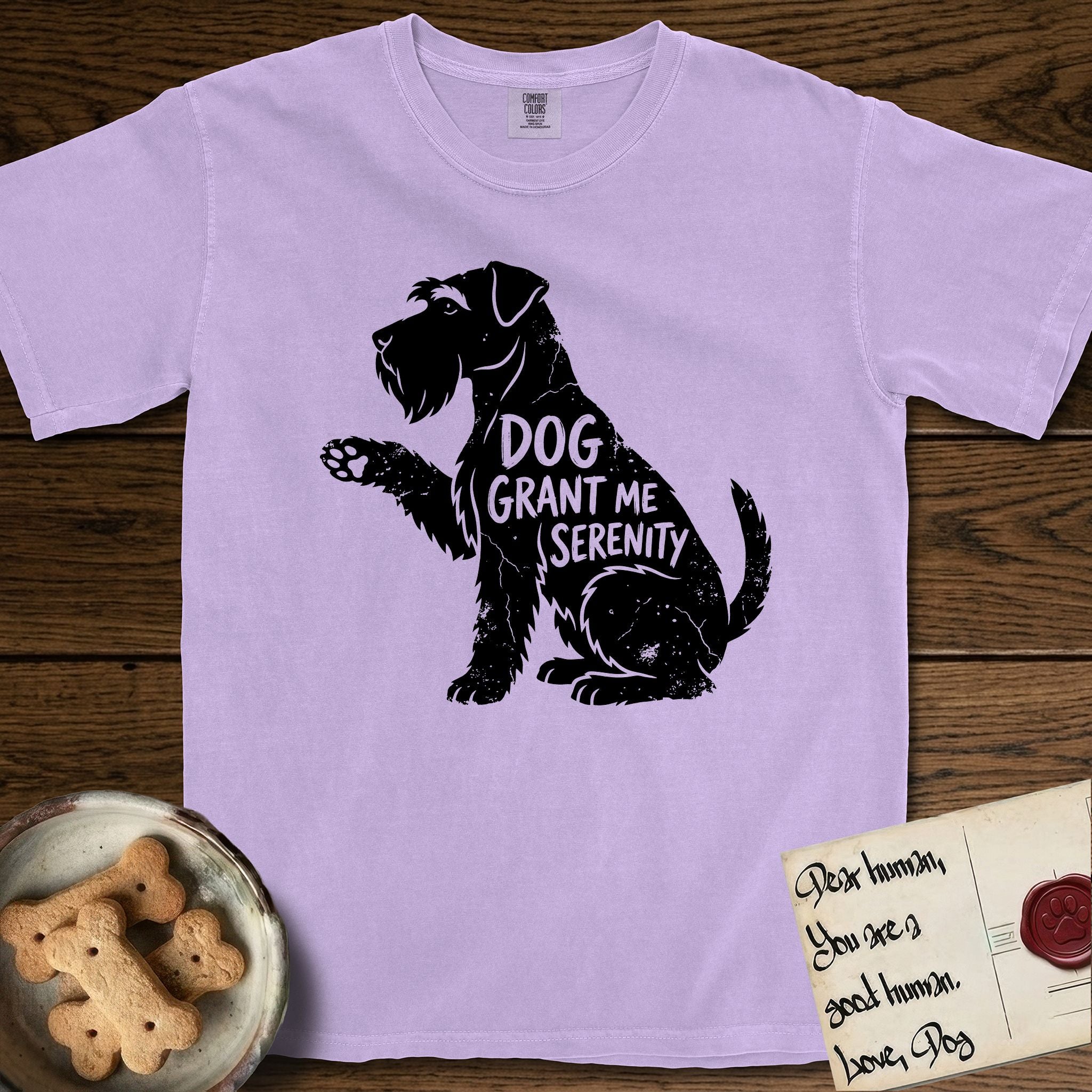 Serenity Schnauzer T-Shirt flat lay in Orchid, featuring Distressed black screen print silhouette of a Schnauzer sitting in profile with one paw raised, a long beard and bushy eyebrows, the words DOG GRANT ME SERENITY showing through her body in the shirt color.