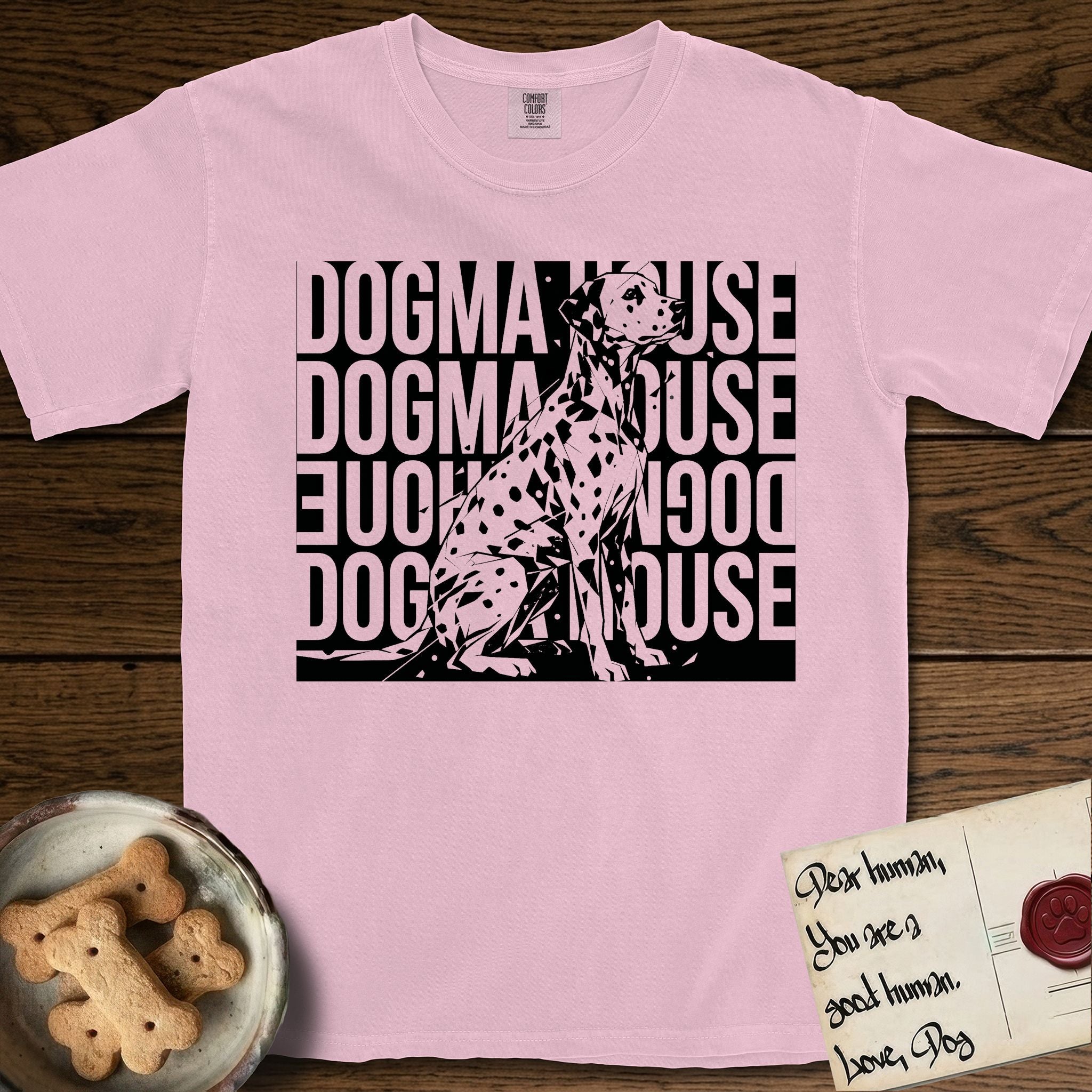 Dogma House Dalmatian T-Shirt flat lay in Blossom, featuring a bold streetwear design with DOGMA HOUSE stacked four times in block letters and a geometric angular Dalmatian overlaid on the text.