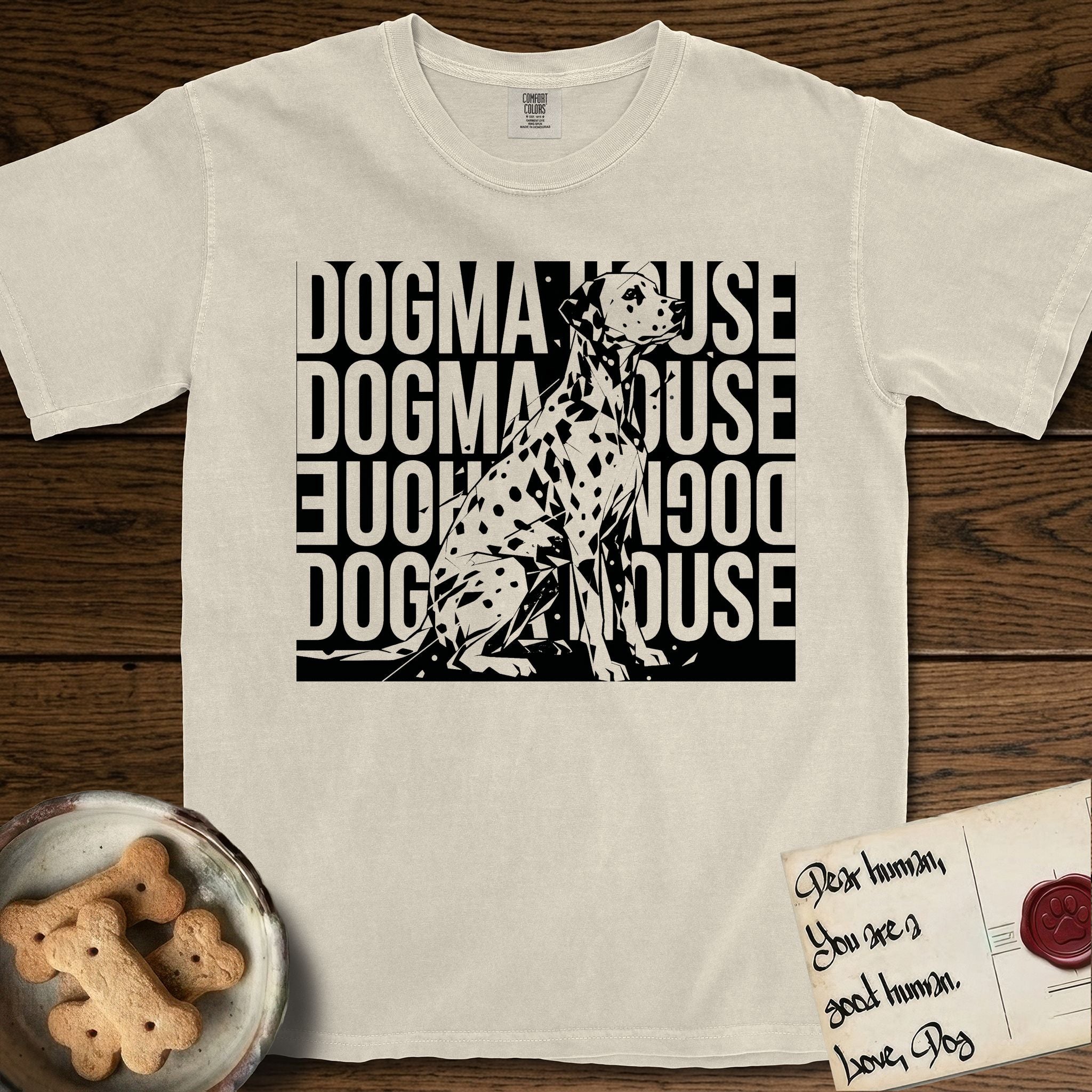 Dogma House Dalmatian T-Shirt flat lay in Ivory, featuring a bold streetwear design with DOGMA HOUSE stacked four times in block letters and a geometric angular Dalmatian overlaid on the text.