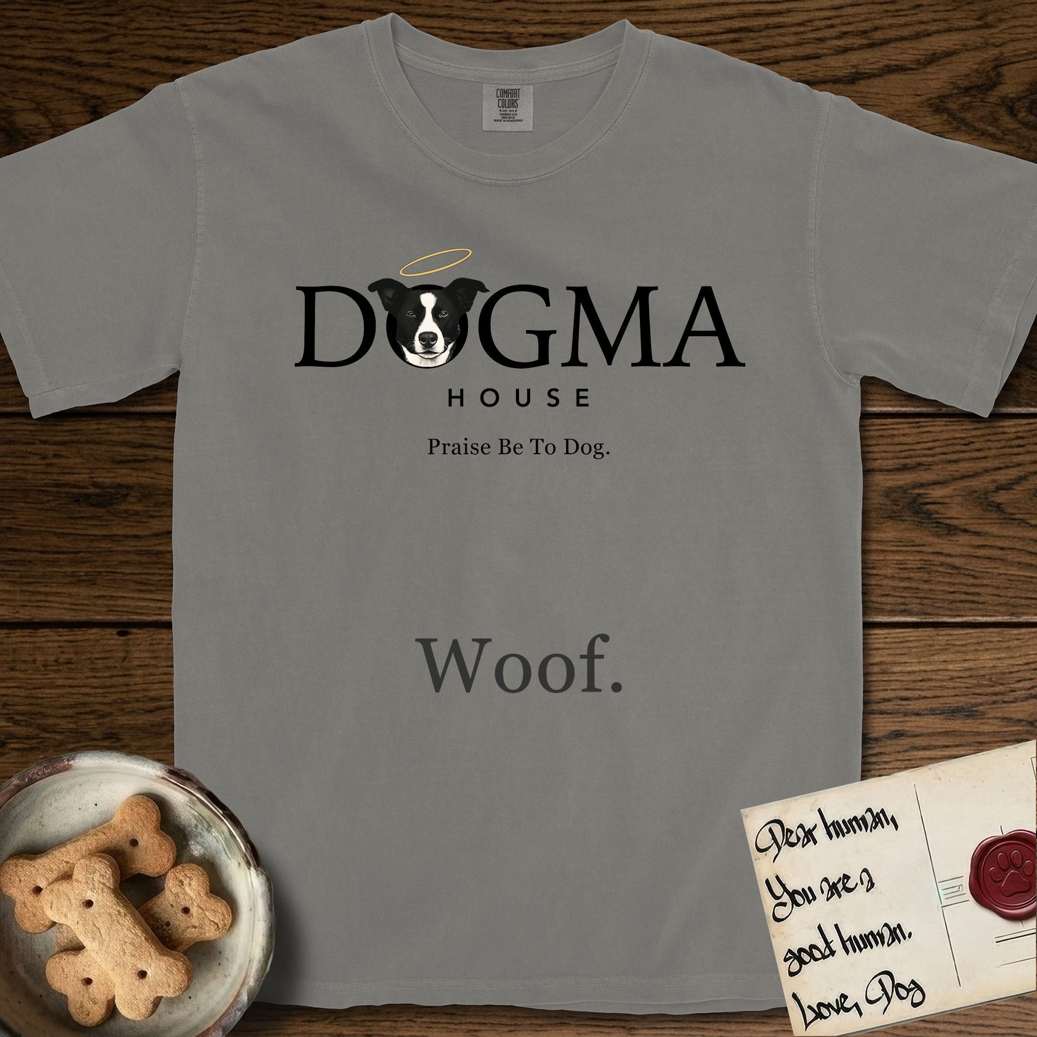 Dogma House Dark Logo T-Shirt flat lay in Grey, featuring the Dogma House wordmark in dark ink with Lobo the mascot forming the O, a halo above him, and HOUSE below.