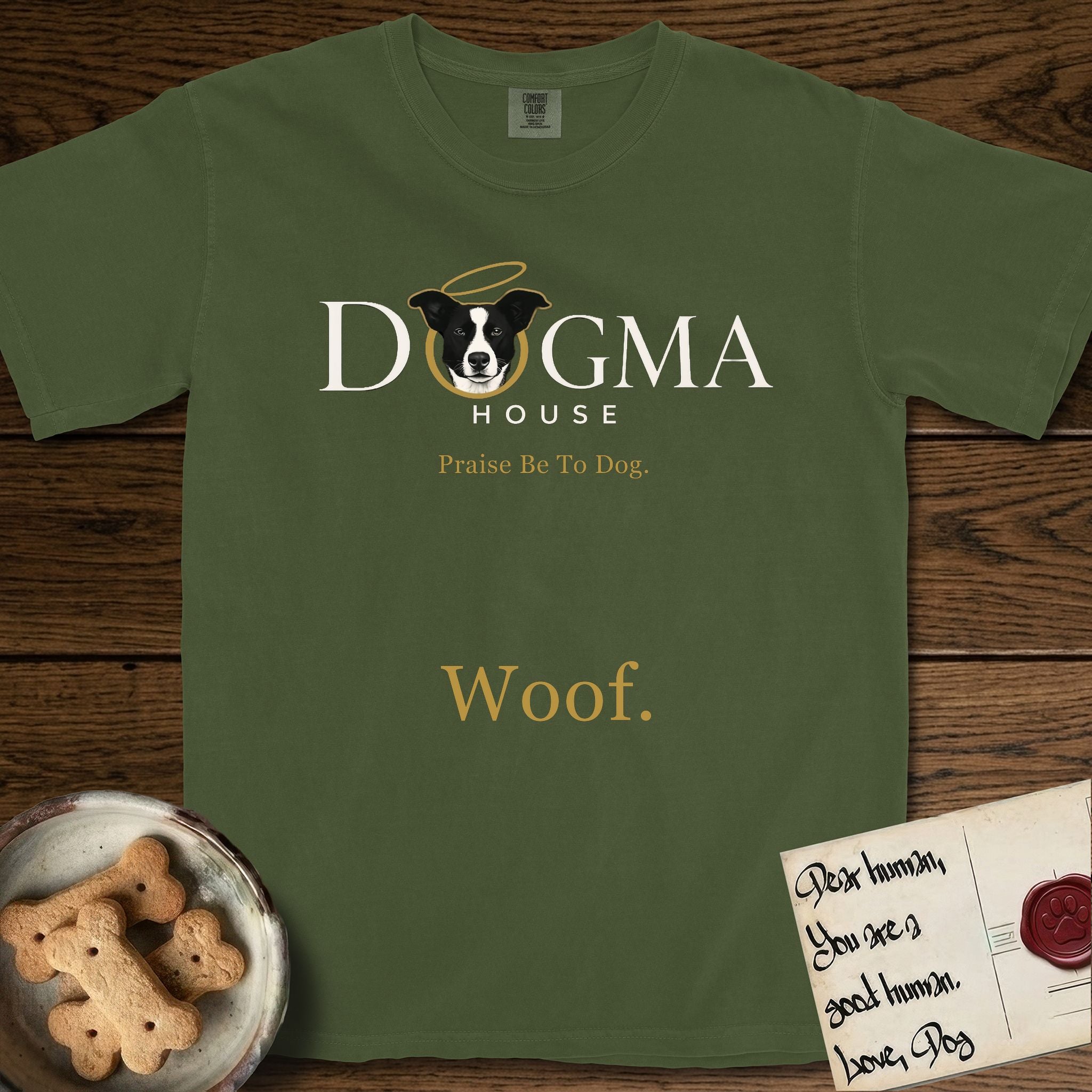 Dogma House Light Logo T-Shirt flat lay in Hemp, featuring the Dogma House wordmark in light ink with Lobo the mascot forming the O, a gold halo above him, and Woof below.