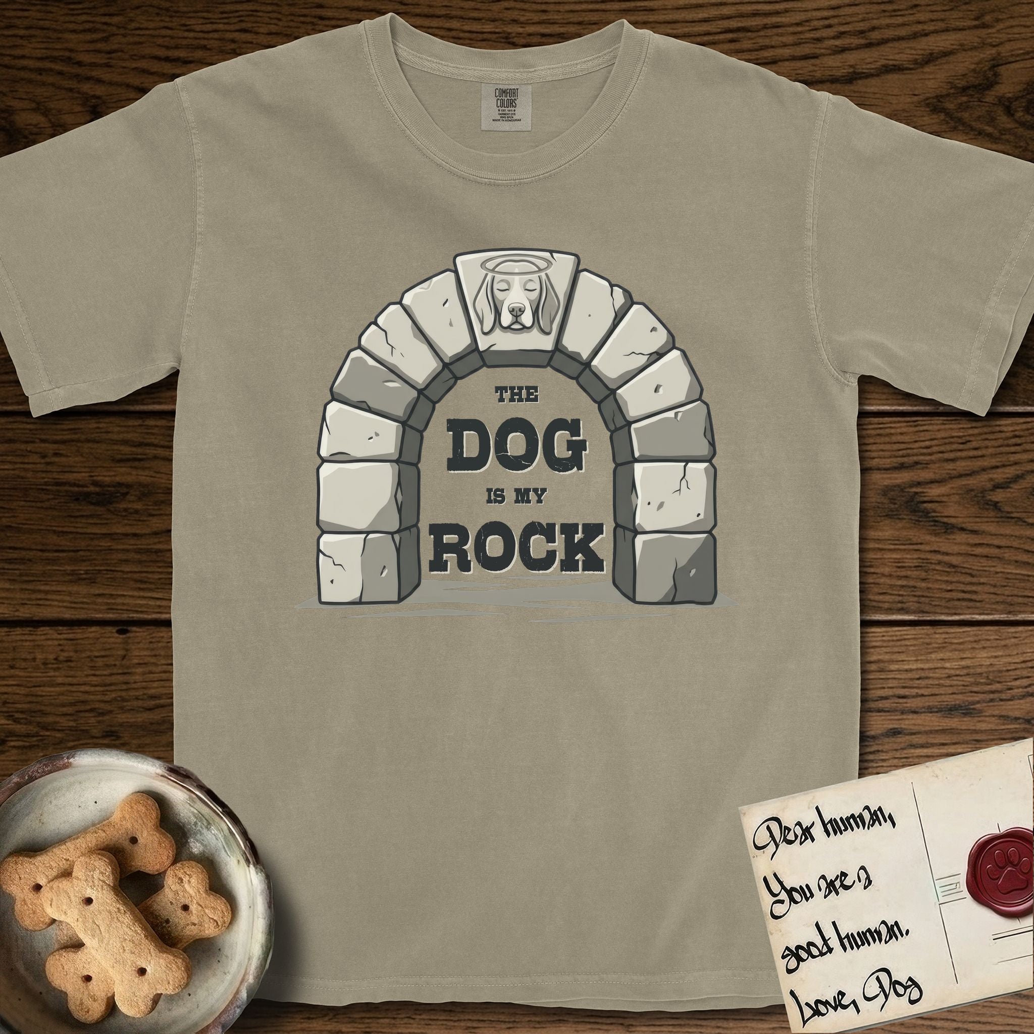 DIMR Beagle T-Shirt flat lay in Khaki, featuring carved gray stone arch with a Beagle's face in shallow relief on the keystone and a halo above, with the words the Dog is my Rock.