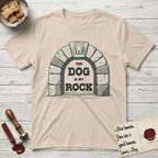 DIMR Beagle T-Shirt flat lay in Sand, featuring carved gray stone arch with a Beagle's face in shallow relief on the keystone and a halo above, with the words the Dog is my Rock.