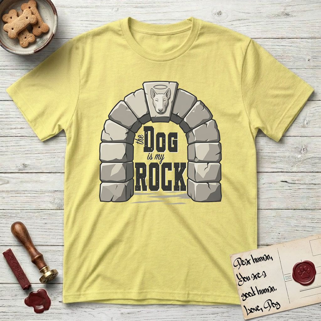 DIMR Bull Terrier T-Shirt flat lay in Cornsilk, featuring carved gray stone arch with a Bull Terrier's face in shallow relief on the keystone and a halo above, with the words the Dog is my Rock.