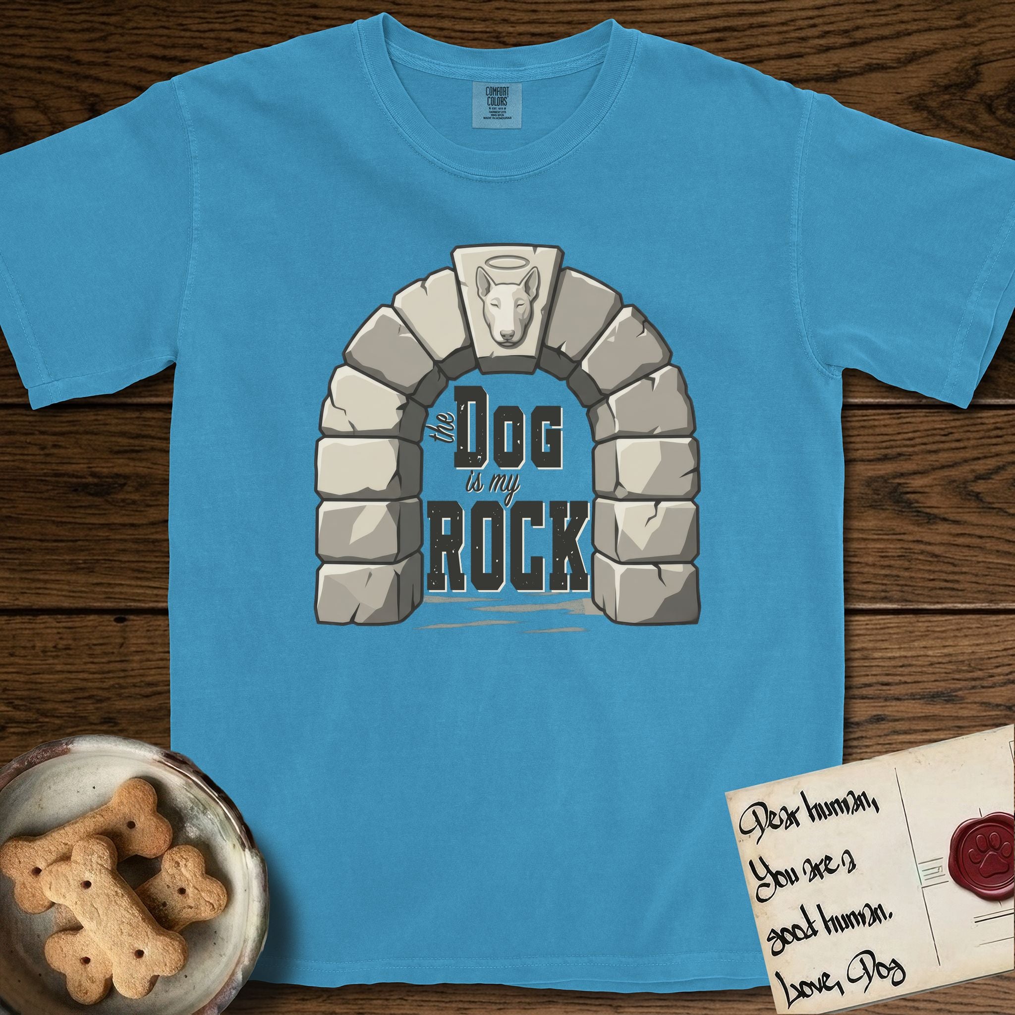 DIMR Bull Terrier T-Shirt flat lay in Royal Caribe, featuring carved gray stone arch with a Bull Terrier's face in shallow relief on the keystone and a halo above, with the words the Dog is my Rock.