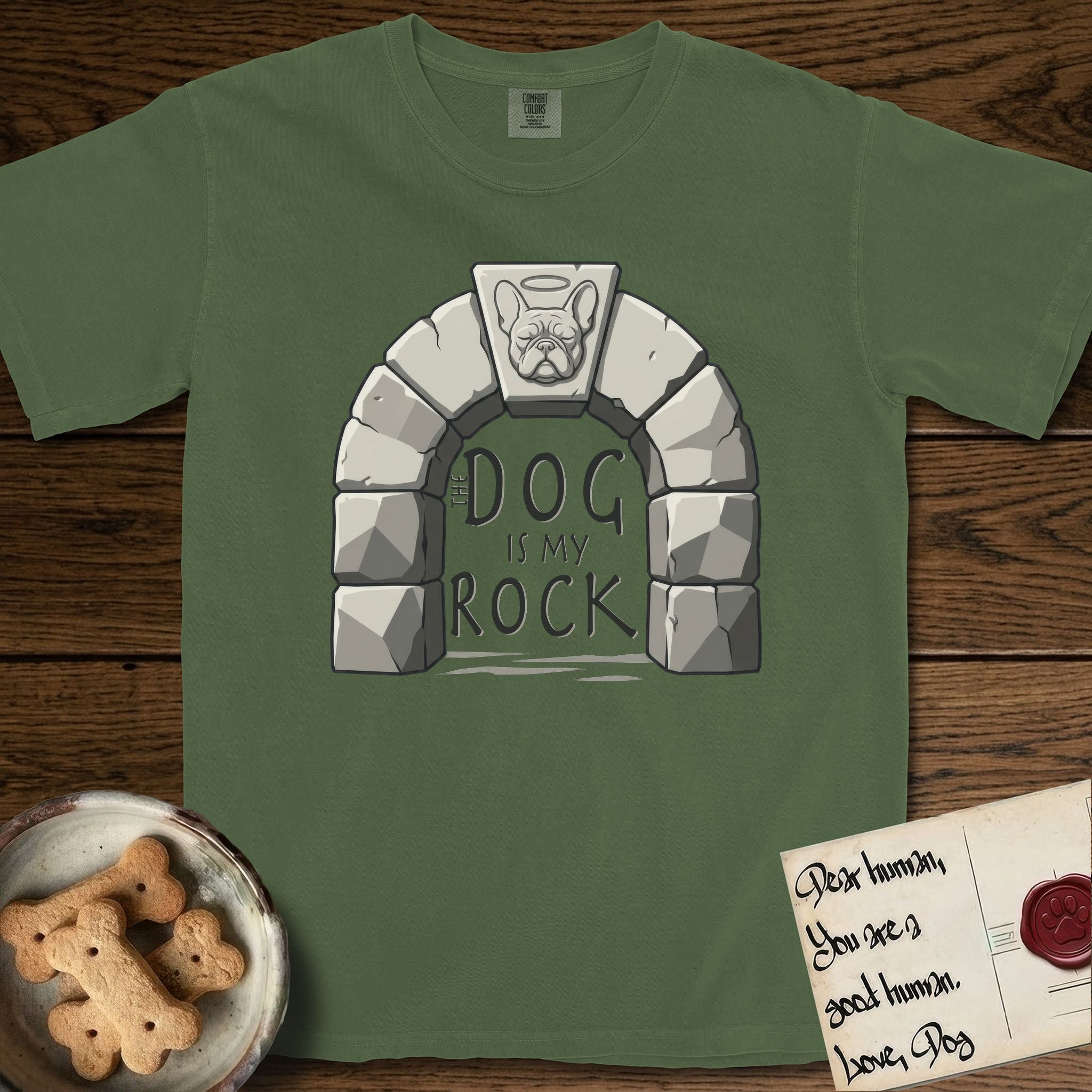 DIMR French Bulldog T-Shirt flat lay in Moss, featuring carved gray stone arch with a French Bulldog's face in shallow relief on the keystone and a halo above, with the words the Dog is my Rock.