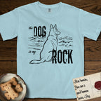 DIMR German Shepherd T-Shirt flat lay in Chambray, featuring ink-line illustration of a German Shepherd seen from behind, sitting at the waterline and watching a stormy sea, with the words the Dog is my Rock.