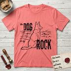 DIMR German Shepherd T-Shirt flat lay in Coral Silk, featuring ink-line illustration of a German Shepherd seen from behind, sitting at the waterline and watching a stormy sea, with the words the Dog is my Rock.