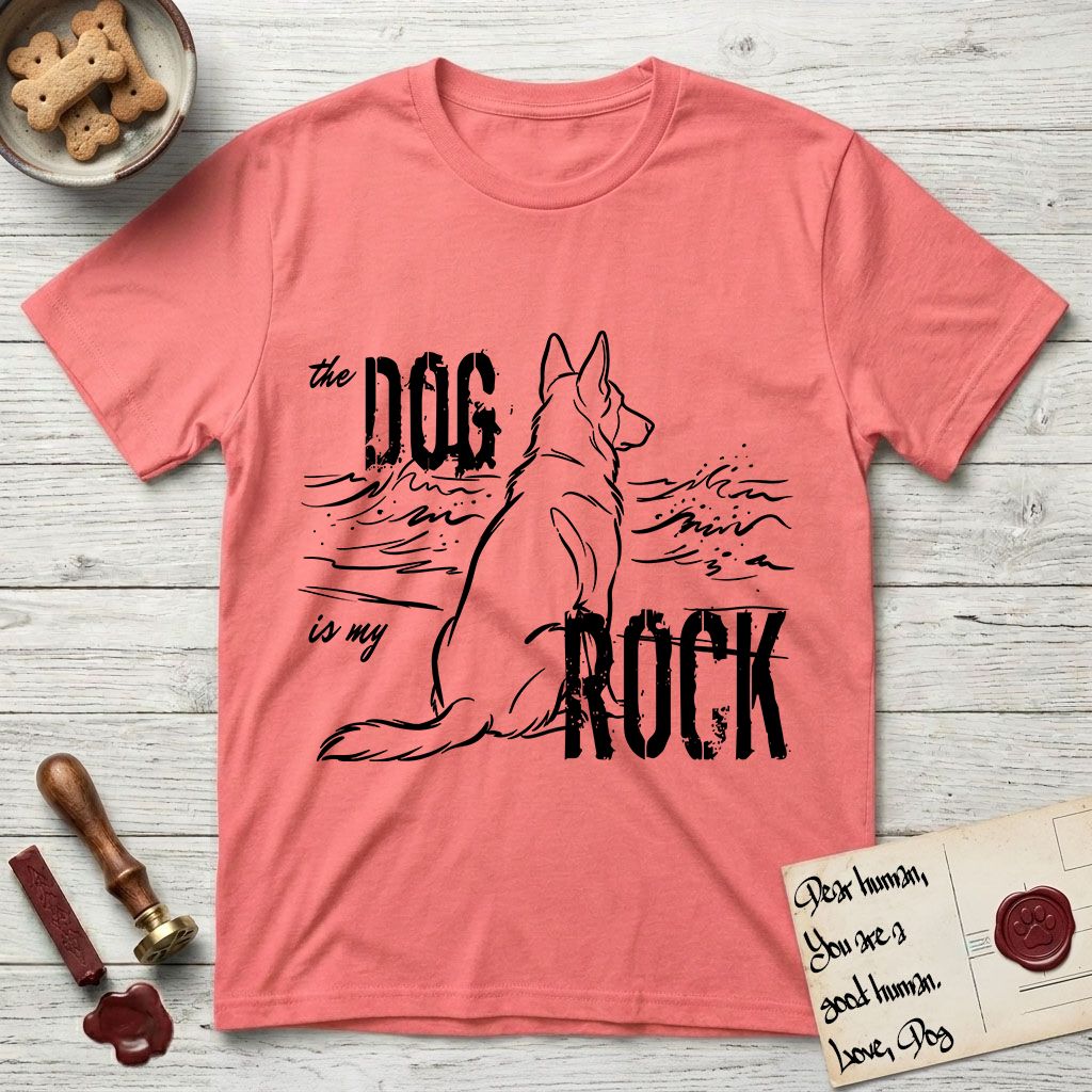 DIMR German Shepherd T-Shirt flat lay in Coral Silk, featuring ink-line illustration of a German Shepherd seen from behind, sitting at the waterline and watching a stormy sea, with the words the Dog is my Rock.