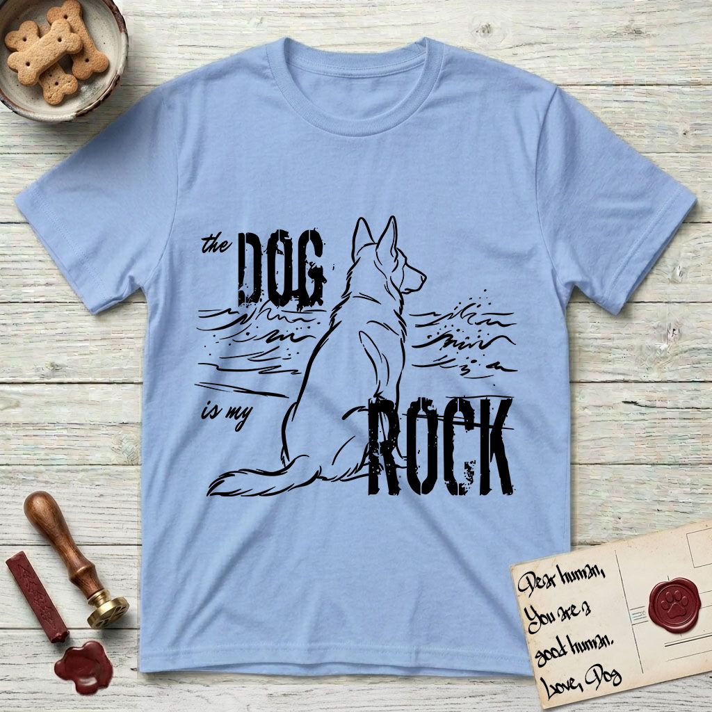 DIMR German Shepherd T-Shirt flat lay in Light Blue, featuring ink-line illustration of a German Shepherd seen from behind, sitting at the waterline and watching a stormy sea, with the words the Dog is my Rock.