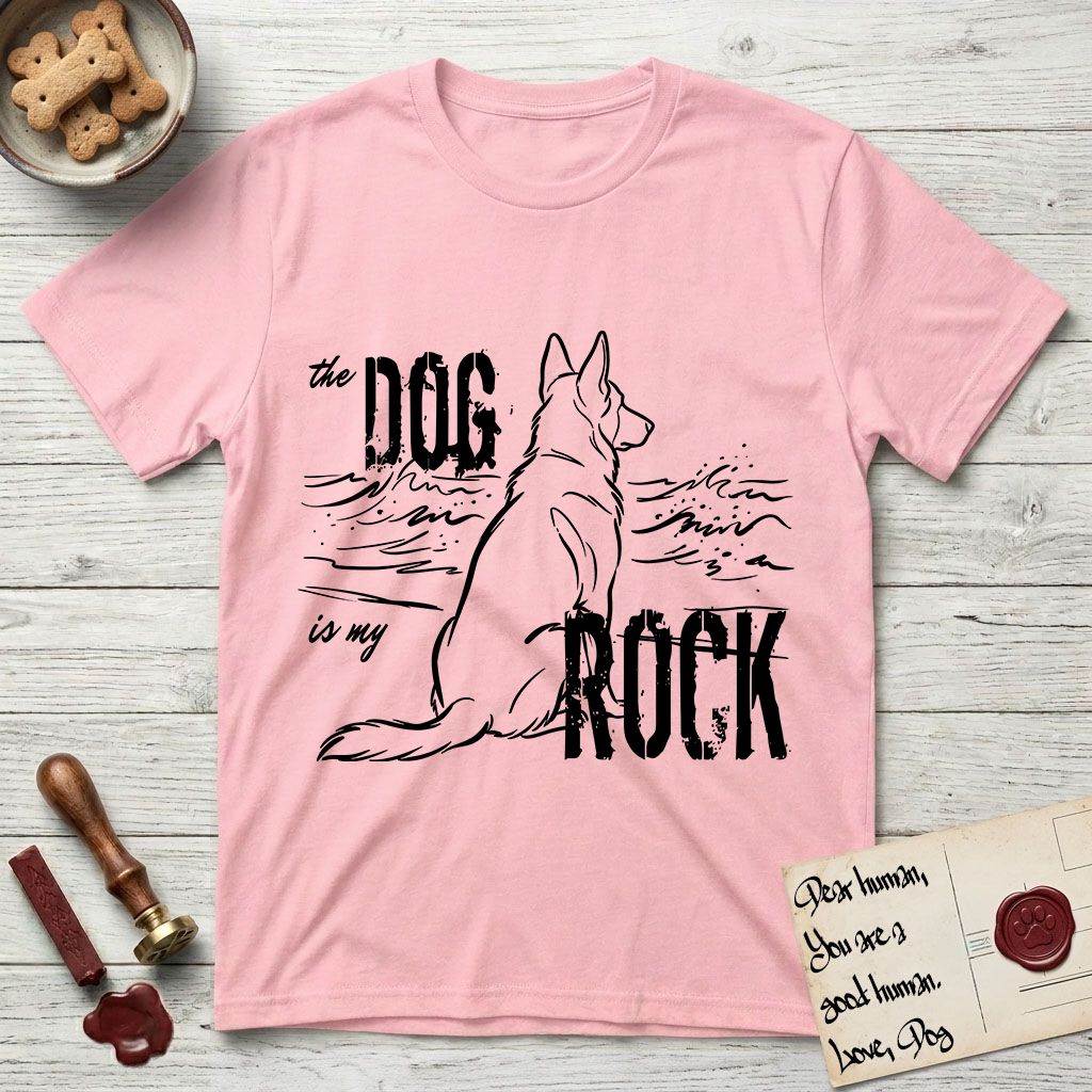 DIMR German Shepherd T-Shirt flat lay in Light Pink, featuring ink-line illustration of a German Shepherd seen from behind, sitting at the waterline and watching a stormy sea, with the words the Dog is my Rock.