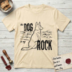 DIMR German Shepherd T-Shirt flat lay in Natural, featuring ink-line illustration of a German Shepherd seen from behind, sitting at the waterline and watching a stormy sea, with the words the Dog is my Rock.
