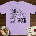 DIMR German Shepherd T-Shirt flat lay in Orchid, featuring ink-line illustration of a German Shepherd seen from behind, sitting at the waterline and watching a stormy sea, with the words the Dog is my Rock.