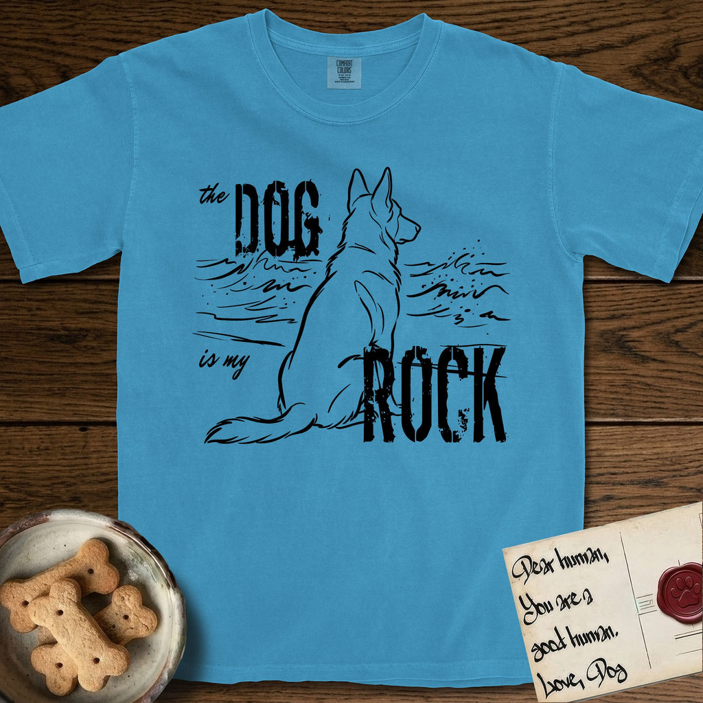 DIMR German Shepherd T-Shirt flat lay in Royal Caribe, featuring ink-line illustration of a German Shepherd seen from behind, sitting at the waterline and watching a stormy sea, with the words the Dog is my Rock.
