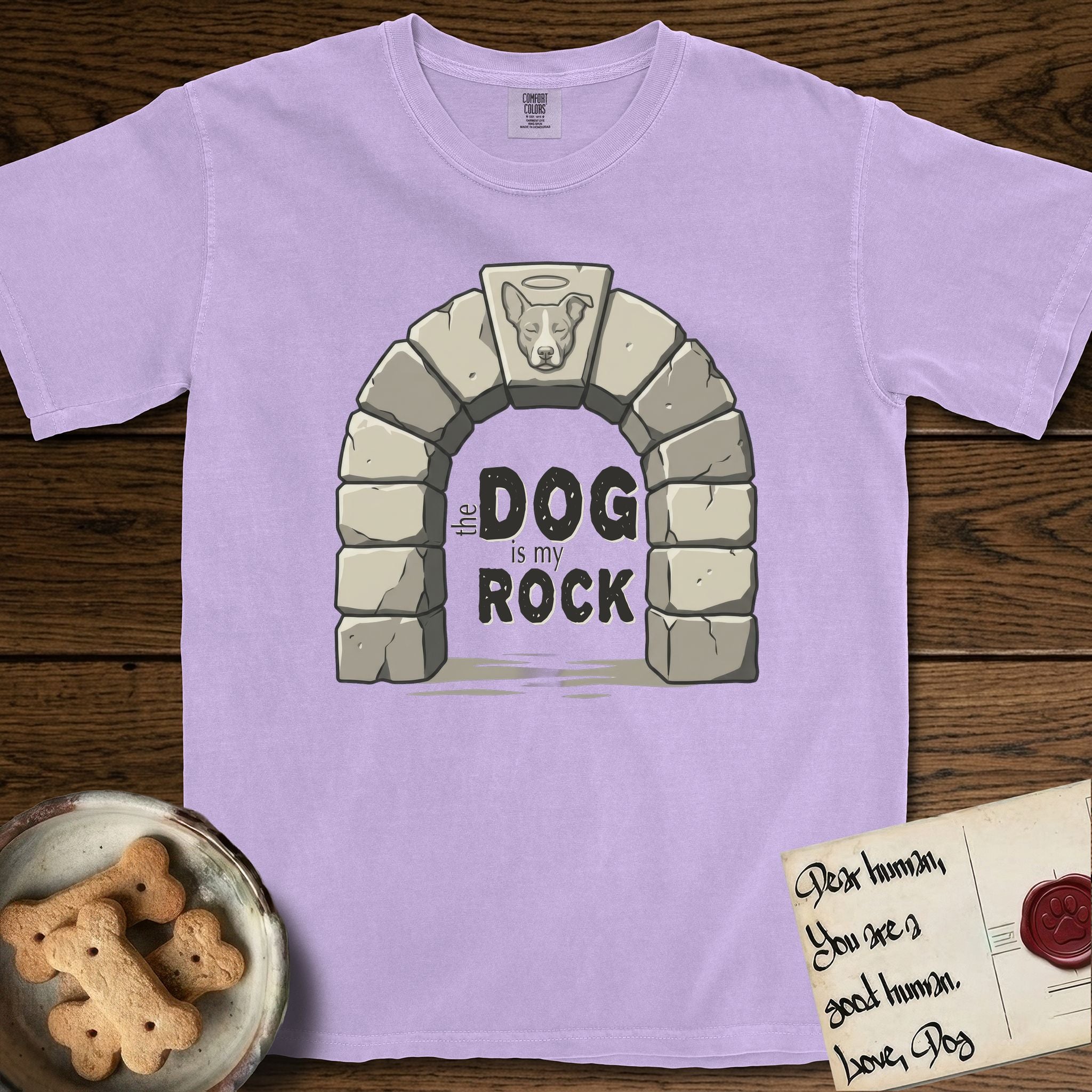 DIMR Lobo T-Shirt flat lay in Orchid, featuring carved gray stone arch with Lobo's Cattle Dog face in shallow relief on the keystone and a halo above, with the words the Dog is my Rock.