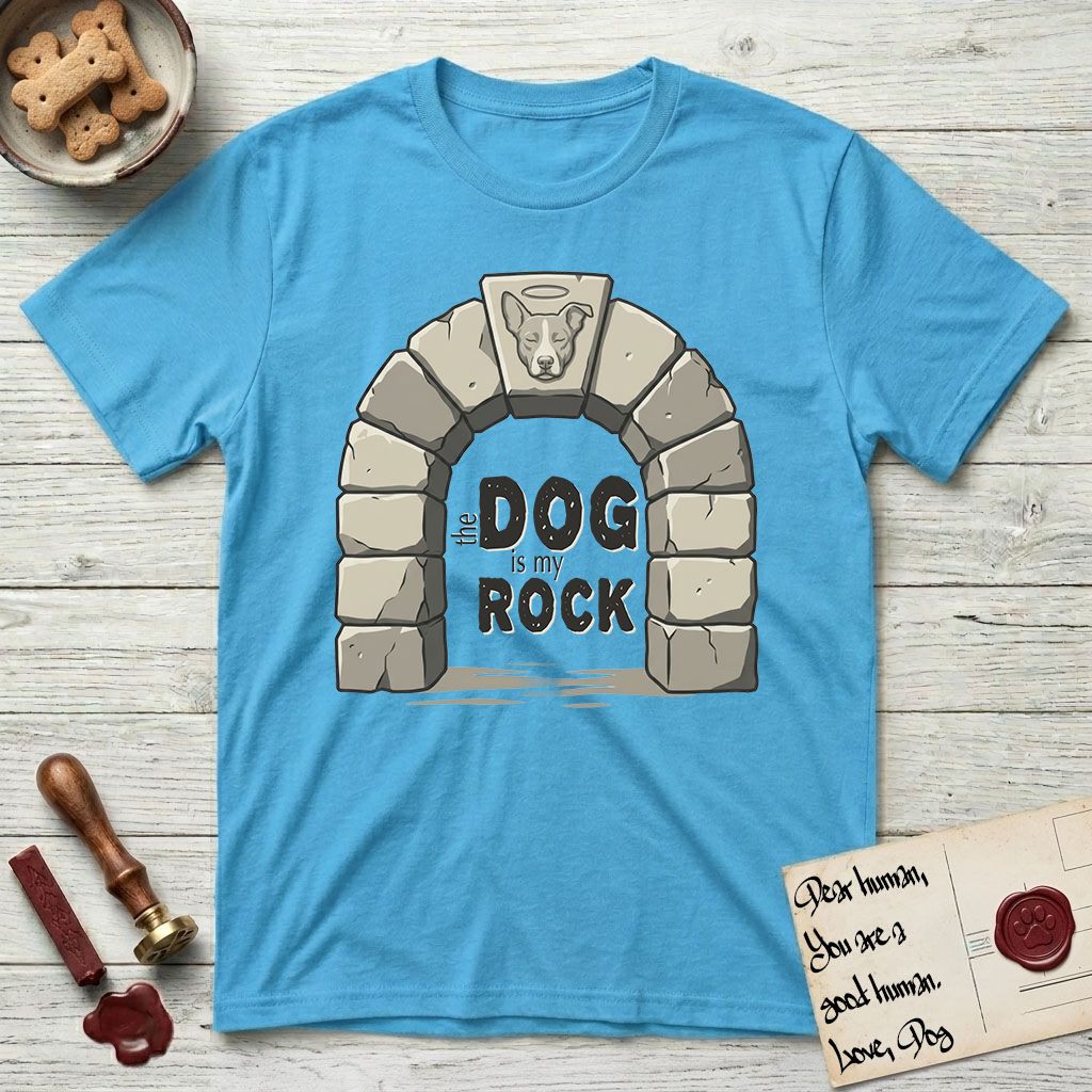 DIMR Lobo T-Shirt flat lay in Sky, featuring carved gray stone arch with Lobo's Cattle Dog face in shallow relief on the keystone and a halo above, with the words the Dog is my Rock.