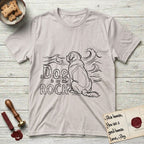 DIMR Saint Bernard T-Shirt flat lay in Ice Grey, featuring ink-line illustration of a Saint Bernard seen from behind, sitting at the water's edge and watching a stormy sea, with the words the Dog is my Rock.