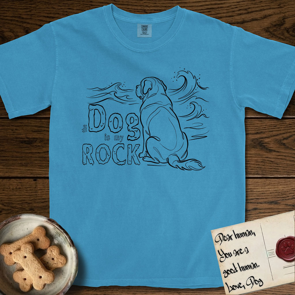 DIMR Saint Bernard T-Shirt flat lay in Royal Caribe, featuring ink-line illustration of a Saint Bernard seen from behind, sitting at the water's edge and watching a stormy sea, with the words the Dog is my Rock.