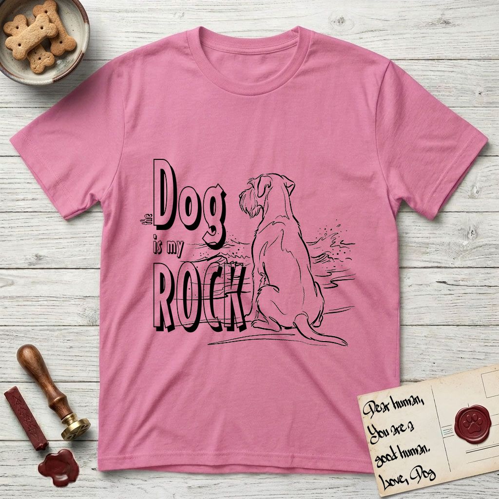 DIMR Schnauzer T-Shirt flat lay in Azalea, featuring ink-line illustration of a Schnauzer seen from behind at the water's edge, head turned toward a stormy sea, with the words the Dog is my Rock.