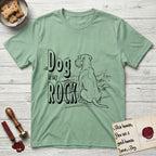 DIMR Schnauzer T-Shirt flat lay in Mint Green, featuring ink-line illustration of a Schnauzer seen from behind at the water's edge, head turned toward a stormy sea, with the words the Dog is my Rock.