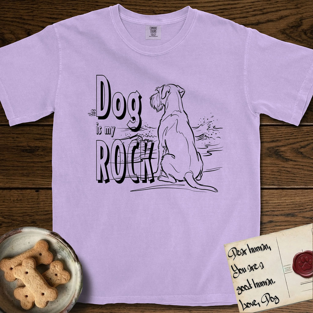 DIMR Schnauzer T-Shirt flat lay in Orchid, featuring ink-line illustration of a Schnauzer seen from behind at the water's edge, head turned toward a stormy sea, with the words the Dog is my Rock.