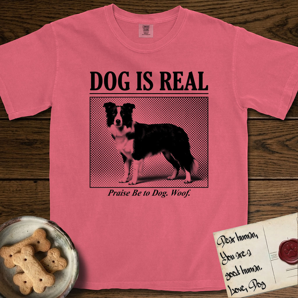 Dog is Real Border Collie T-Shirt flat lay in Watermelon, featuring Black halftone newspaper photo of a black and white Border Collie standing in profile with head turned to the camera, under the headline DOG IS REAL, with the caption Praise Be to Dog. Woof..
