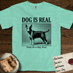 Dog is Real Bull Terrier T-Shirt flat lay in Island Reef, featuring Black halftone newspaper photo of a Bull Terrier with a white face standing in profile with head turned to the camera, under the headline DOG IS REAL, with the caption Praise Be to Dog. Woof..