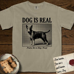 Dog is Real Bull Terrier T-Shirt flat lay in Khaki, featuring Black halftone newspaper photo of a Bull Terrier with a white face standing in profile with head turned to the camera, under the headline DOG IS REAL, with the caption Praise Be to Dog. Woof..