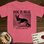 Dog is Real German Shepherd T-Shirt flat lay in Watermelon, featuring Black halftone newspaper photo of a black and tan German Shepherd with upright ears standing in profile with head turned to the camera, under the headline DOG IS REAL, with the caption Praise Be to Dog. Woof..