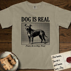 Dog is Real Pitbull T-Shirt flat lay in Khaki, featuring Black halftone newspaper photo of a broad-chested Pitbull standing in profile with head turned to the camera, under the headline DOG IS REAL, with the caption Praise Be to Dog. Woof..